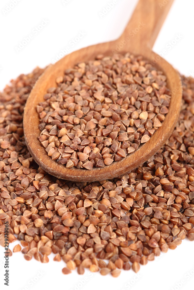 Buckwheat seeds on wooden spoon. Isolated on white background. Buckwheat seeds on wooden spoon. Isolated on white background.