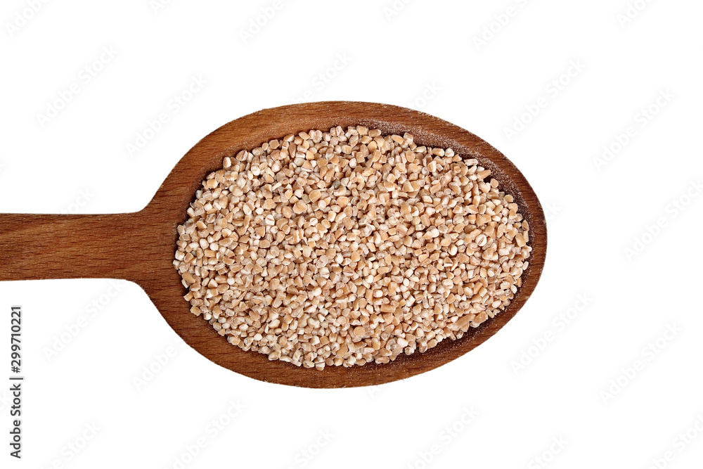 Spelt groats on wooden spoon. Isolated on white background. Directly Above. Spelt groats on wooden spoon. Isolated on white background. Directly Above.