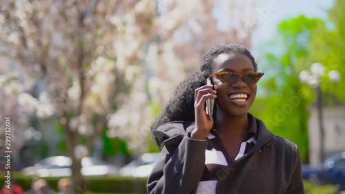Young african woman talk phone on the street