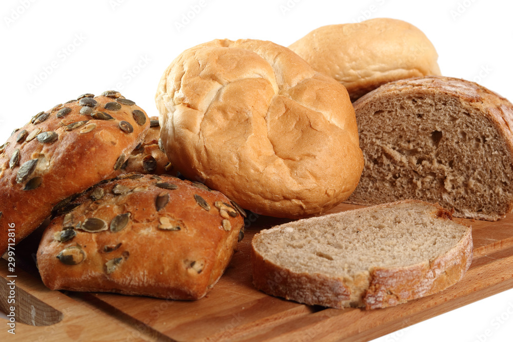 Rye bread, pumpkin and kaiser roll on cutting board. Isolated on white background. Rye bread, pumpkin and kaiser roll on cutting board. Isolated on white background.