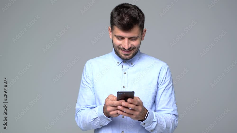 Man texting on the phone isolated on gray background Man texting on the phone isolated on gray background