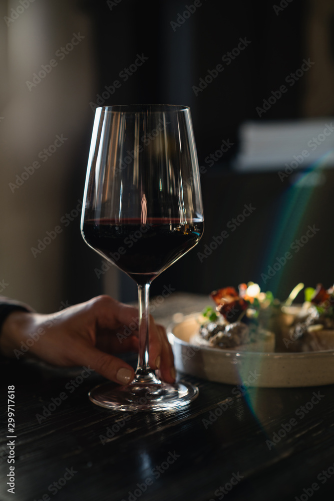 Holding glass with red wine in the restaurant