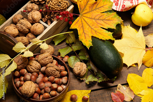 Fruits and vegetables with apples, corn, nuts, berries - autumn harvest and healthy food concept. Yellow leaves. Still life on wooden background.