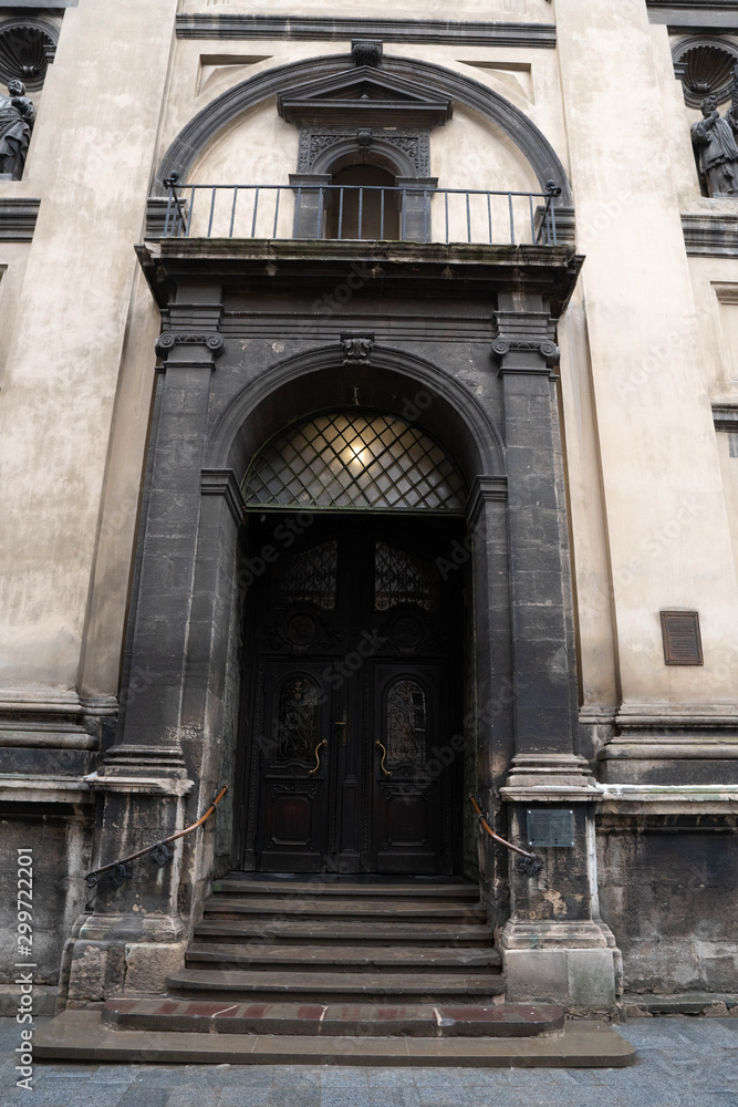 Fototapeta premium Closeup of Dominican Church in Lviv. Old building with staircase. Entrance Stairs The Door Old. Door to the Catholic Church. Stairs to the Church