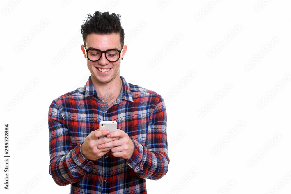 Portrait of happy young handsome hipster man using phone