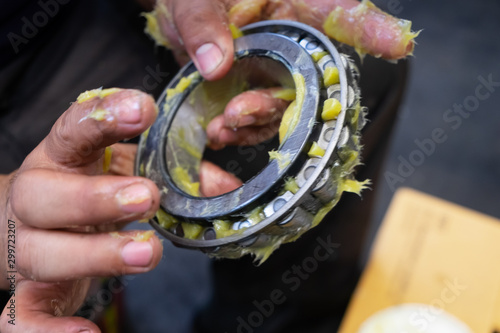 Putting lithium grease into wheel bearing for ten wheel track by hand photo