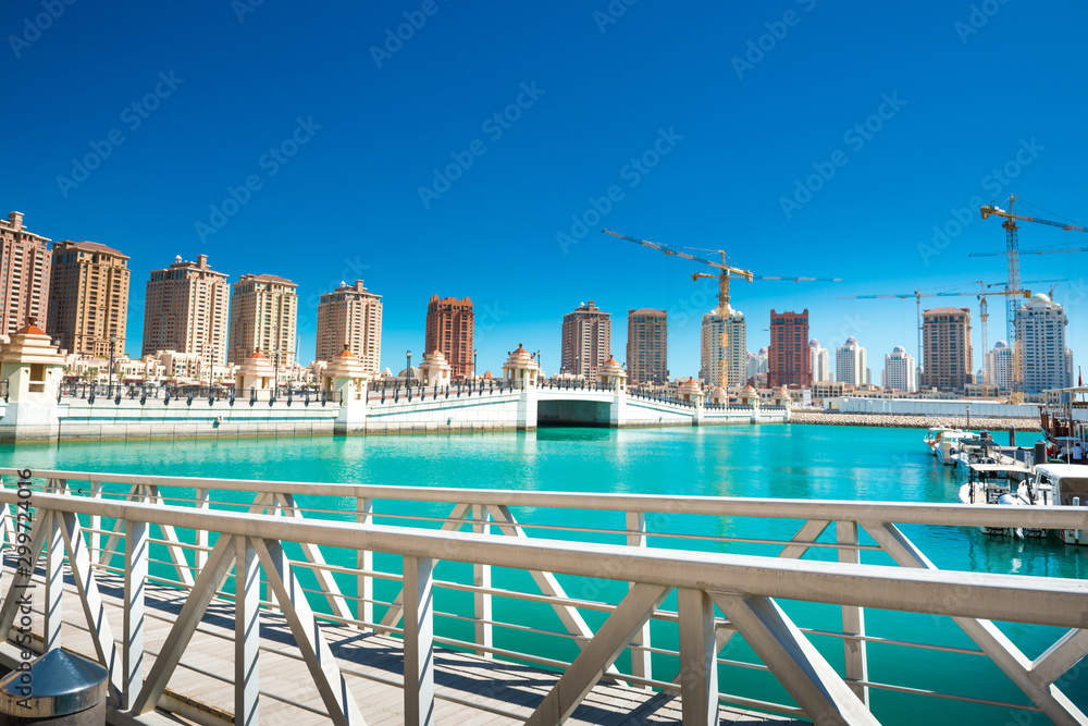 Luxury residential buildings of Pearl-Qatar and white yachts at Porto Arabia marina. Doha, Qatar