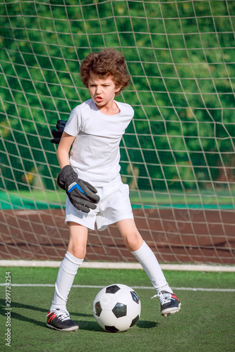 Summer soccer tournament for young kids. football club. emotions and joy of the game. Young goalie. Kids - soccer champion. Boy goalkeeper in football sportswear on stadium with ball. Sport concept. © kravik93