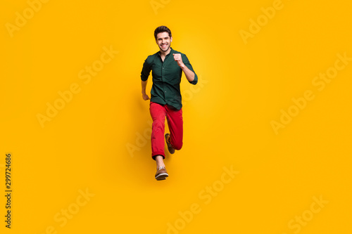Full length photo of positive cheerful funky man jump run fast hurry buy under black friday sales wear casual style clothes sneakers isolated over yellow color background