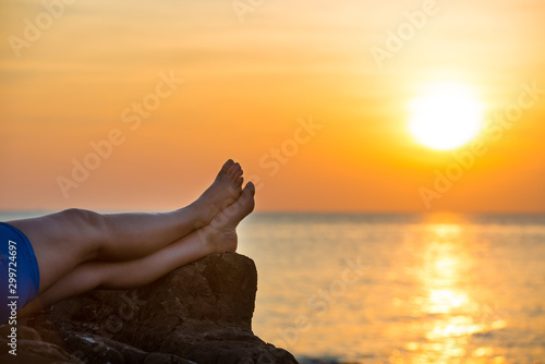 Bare human feet on beautiful sea sunset background. Summer vacation concept © Pavlo Vakhrushev