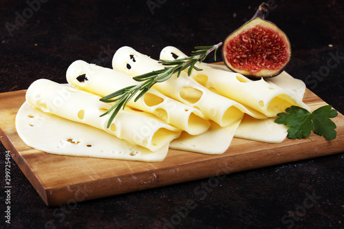 cheese slices on wooden tray with parsley. gauda cheese photo