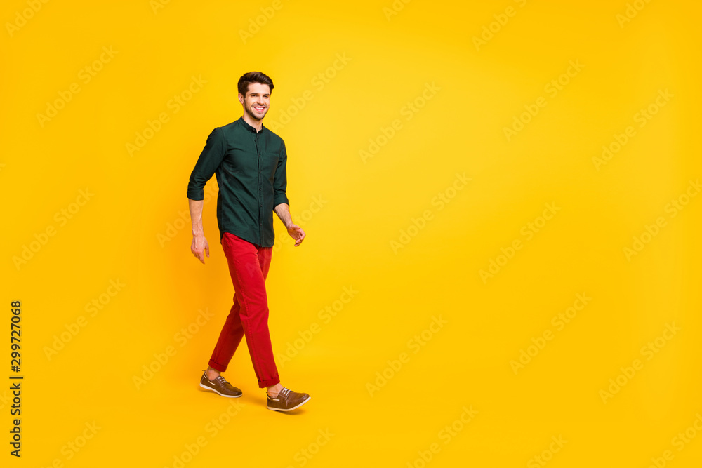 Full length photo of positive cheerful guy have free time go walk wear casual style outfit sneakers isolated over yellow color background