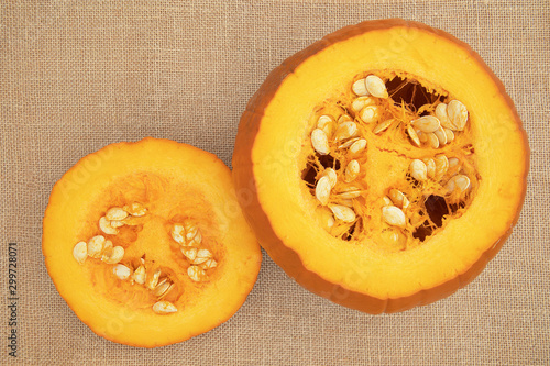 Focus stacked image of a pumpkin with top cut off, displayed on hessian background shot from above