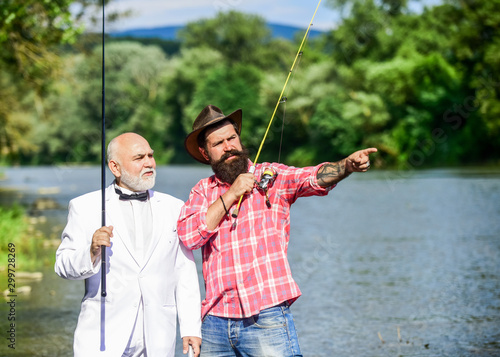 Friends fishing. Elegant bearded man and brutal hipster fishing. Perfect weekend. Hobby and recreation. Family day. Summer vacation. Fishing as holiday. Fisherman in formal suit. Successful catch