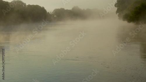 Beautiful dramatic misty landscape. Fog over peaceful morning surface of river or lake outside. Landscape of Ukraine at early morning before sunrise. Real time full hd video footage.