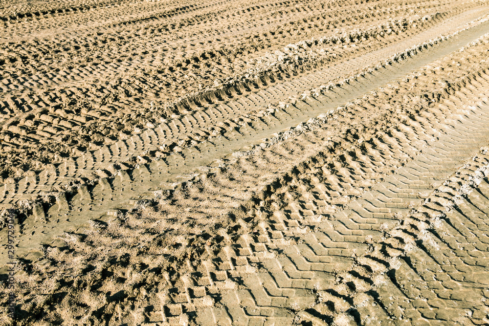 Fototapeta premium tracks on the sand from the wheels and tracks of a tank, tractor, machine or bulldozer