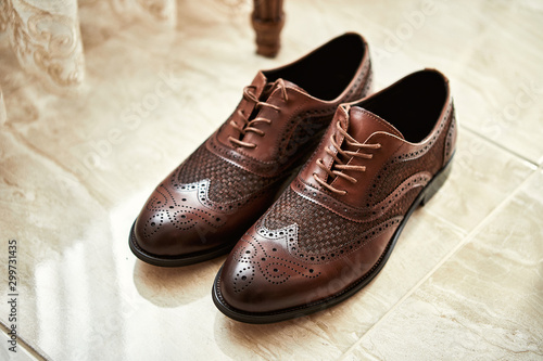 Men's shoes lie on the floor. Different accessories of businessman for creating style of people on wooden background