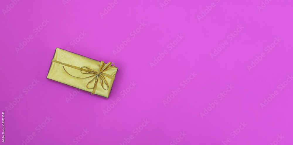Golden box with a bow. Gift on a colored pink background. Great design for any purposes. Fashion, glamor background. New year, Christmas design Golden box with a bow. Gift on a colored pink background. Great design for any purposes. Fashion, glamor background. New year, Christmas design