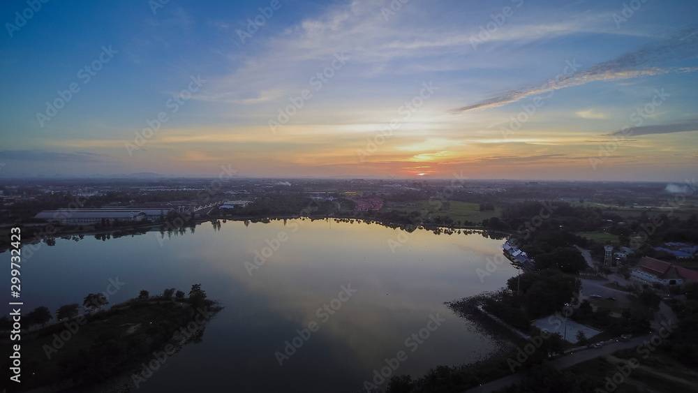 Fototapeta premium Aerial view evening above reservoir with red sun light and cloudy sky background, sunset at Krajub reservoir, Nong Kob, Ban Pong, Ratchaburi, Thailand.