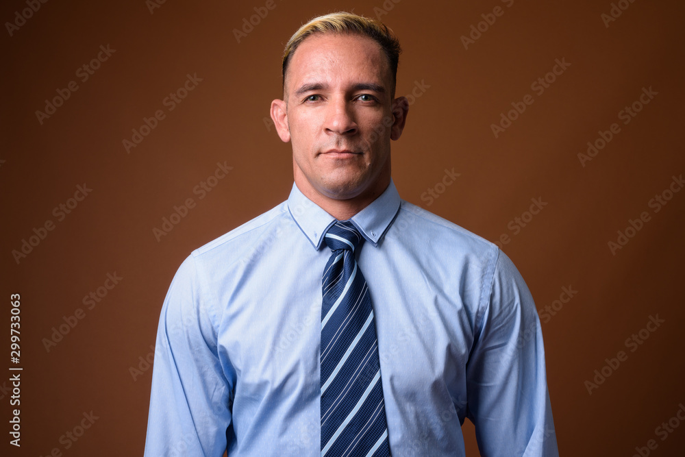 Studio shot of businessman against brown background Studio shot of businessman against brown background