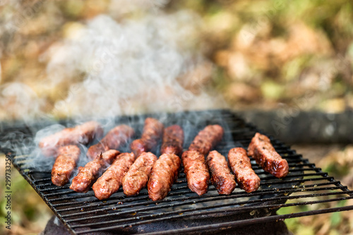 Balkan cuisine Pork Cevapi, grilled minced meat, on the improvised grill photo