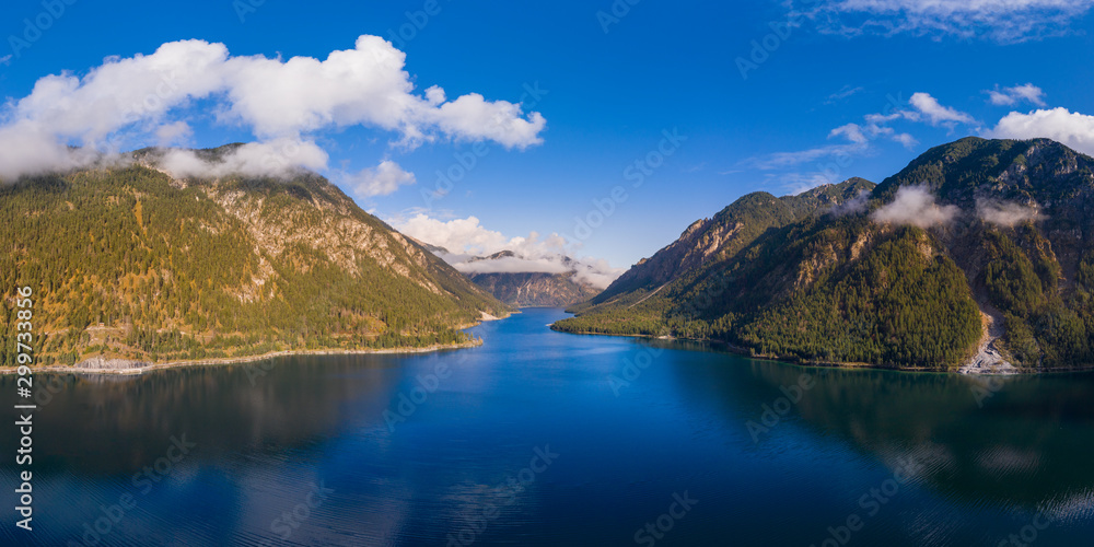 panorama of deep blue Plansee with cloudy sky and mount Zwieselberg Geierkoepfe and Spiessberg