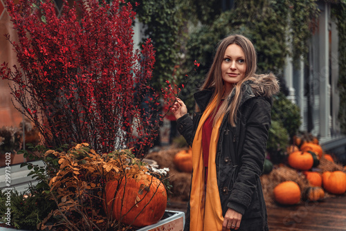 A girl walks through the autumn city. Pumpkins decorate the streets © Valeriia