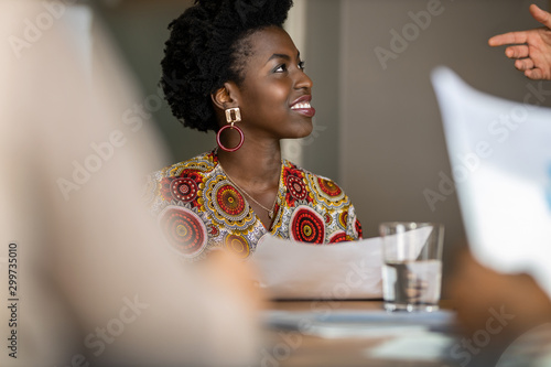 Beautiful young confident professional black african business woman smiling in meeting photo