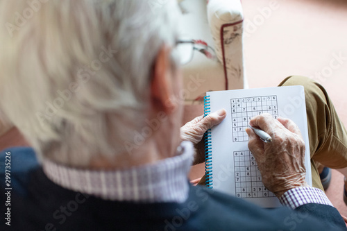 Tableau sur toile Senior Man Doing Sudoku Puzzle At Home