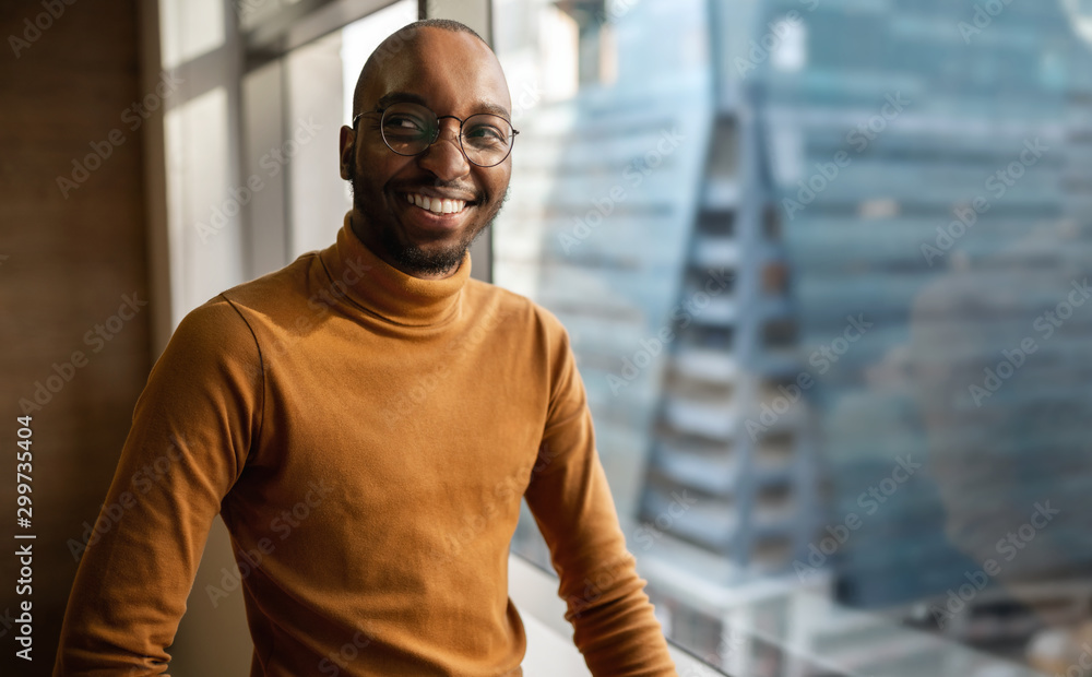 © JonoErasmus - Millennial black african creative and trendy business entrepreneur smiling and looking away. With copyspace