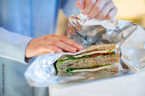 Close Up Of Woman Wrapping Sandwich In Non Reusable Aluminium Foil photo