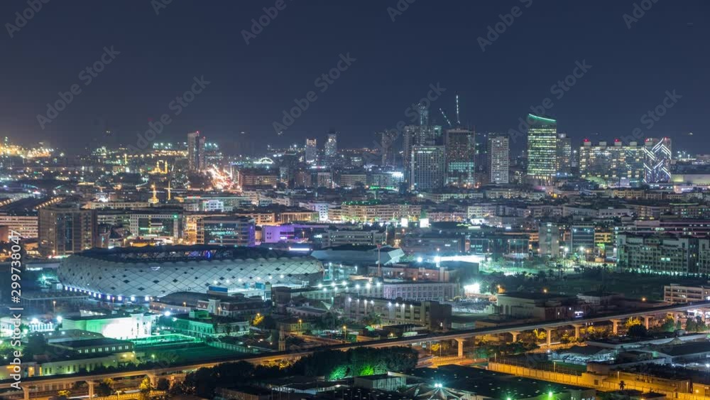 Beautiful view of bright lights from city buildings and stadium with fast rhythm at evening aerial timelapse in Financial center, Dubai, United Arab Emirates Beautiful view of bright lights from city buildings and stadium with fast rhythm at evening aerial timelapse in Financial center, Dubai, United Arab Emirates