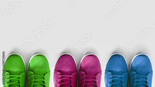 group of multi-colored sneakers on a white background. Concept - a problem with the choice of shoe colors in the modern industry, copyspace, flatlay