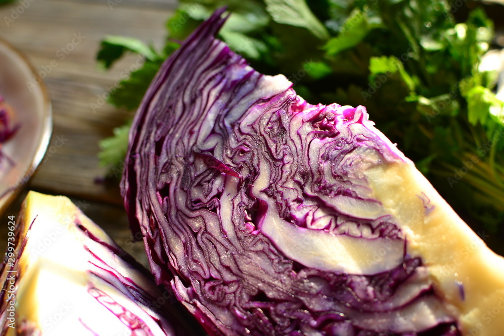Obraz premium Fresh vegetables in the sunlight. Red cabbage and parsley. Vegetarian wholesome food. Red cabbage in a cut.