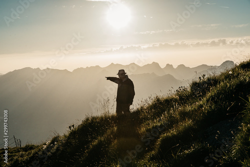 Silhouette eines Mannes der in den Sonnenuntergang zeigt