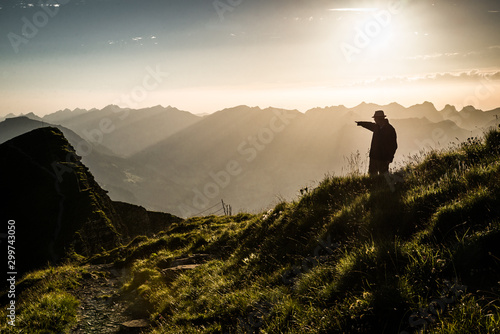 Silhouette eines Mannes der in den Sonnenuntergang zeigt