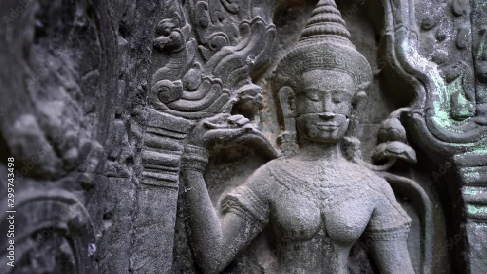 4K, God statue at Ta Prohm temple. Figure of one deities in Hinduism. Ancient monument ruins in Angkor Thom Cambodia. A popular tourist destination near Siem Reap in Asia.-Dan 4K, God statue at Ta Prohm temple. Figure of one deities in Hinduism. Ancient monument ruins in Angkor Thom Cambodia. A popular tourist destination near Siem Reap in Asia.-Dan
