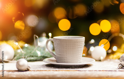 White coffee mug with gold shiny Christmas decorations.