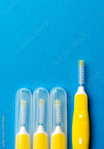 Interdental brush for interdental spaces over blue background. The concept of good mouth hygiene