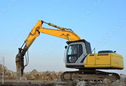 Crawler excavator with hydraulic breaker hammer for the destruction of concrete and hard rock at the construction site or quarry. Jackhammer using without blasting method. Hard rock demolition