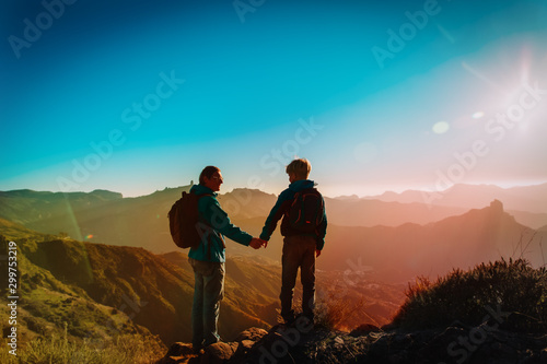 Father and son travel in sunset mountains, family hiking in nature