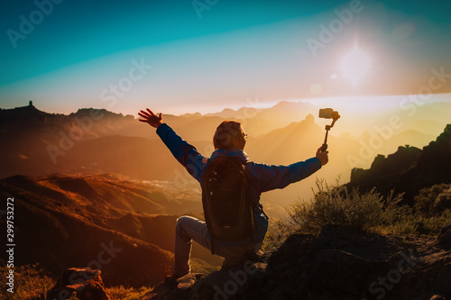 happy tourist making selfie in mountains, hiking in nature