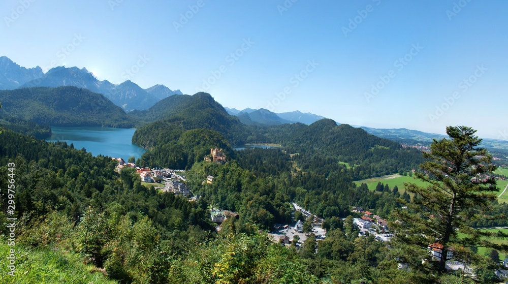 View of Bavaria countryside with rolling mountains, trees, and Lake Alpsee