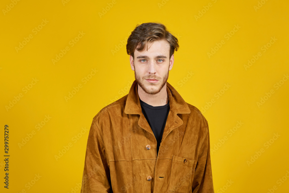 Fototapeta premium good looking guy looking at the camera on a yellow background