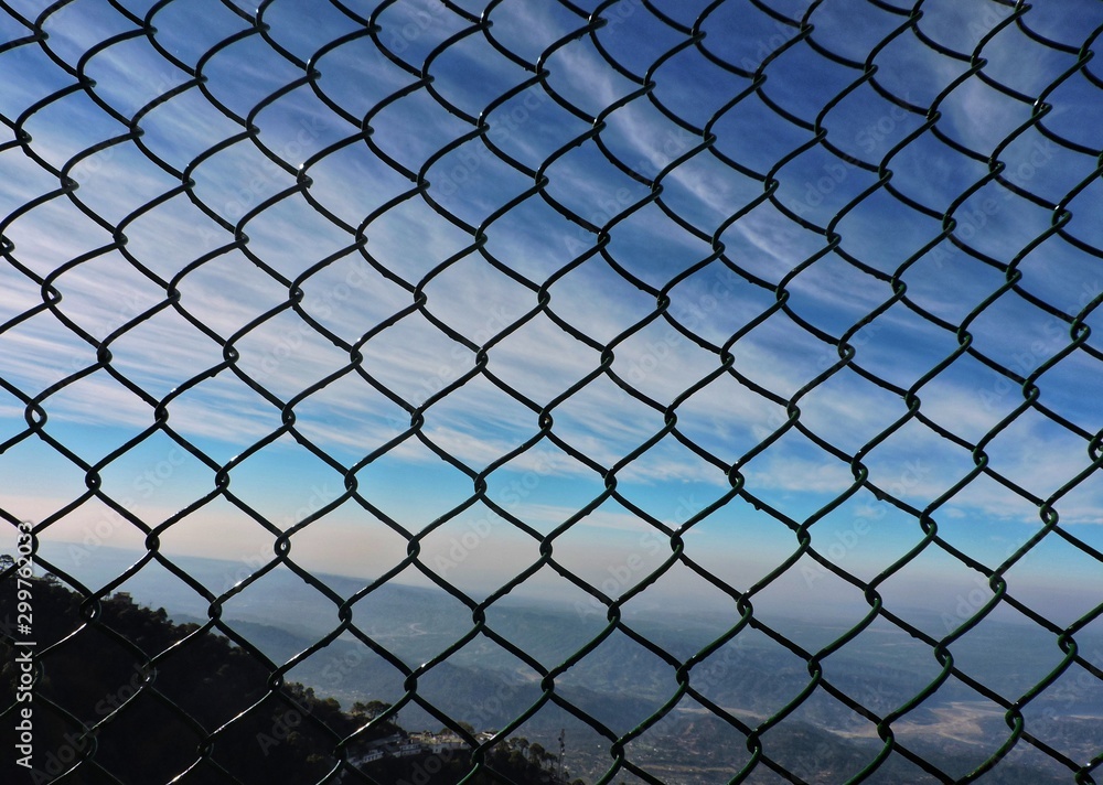 Naklejka premium Clouds and scenery behind fence