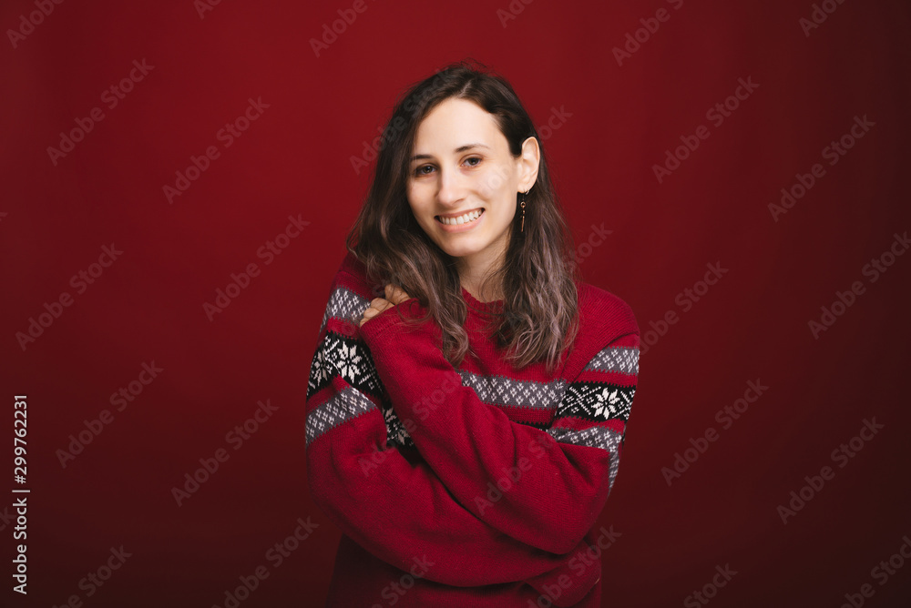 Portait of charming smiling young woman in red sweater looking confident at the camera Portait of charming smiling young woman in red sweater looking confident at the camera