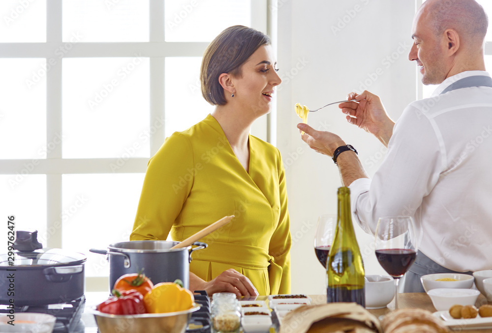 Smiling young couple cooking food in the kitchen Smiling young couple cooking food in the kitchen