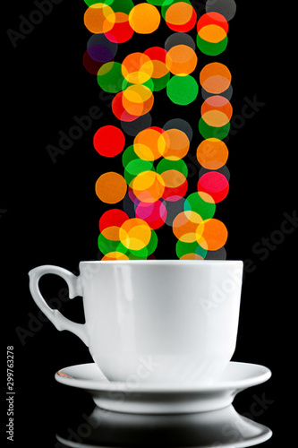 White cup with beautiful bokeh from the lights of a garland