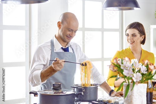 Fototapeta Naklejka Na Ścianę i Meble -  Smiling young couple cooking food in the kitchen