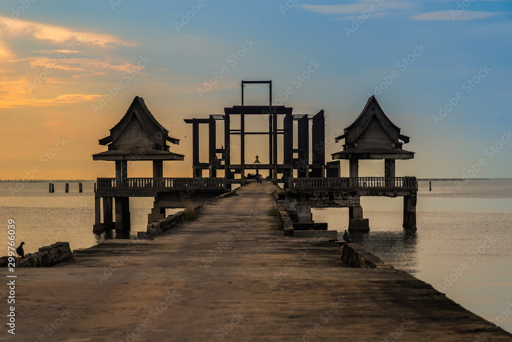 Chon Burii, Thailand - October, 06, 2019 :  Landscape of old bridge in the sea at sunset time Djittabhawan temple Pattaya, Thailand.